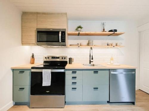 皮克顿Scandi Inspired 2 Bed Suite Sandbanks Pass Incl的厨房配有炉灶和微波炉。