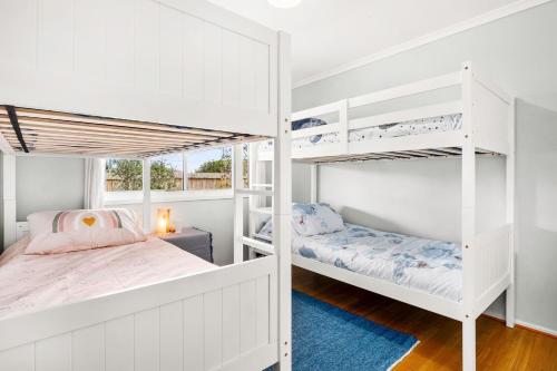 Surf BeachCalm 3922的一间带白色双层床的卧室和蓝色地毯