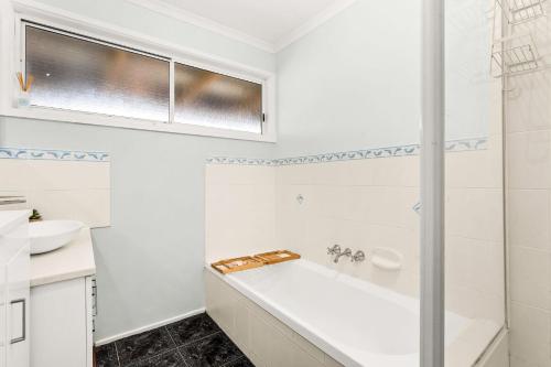 Surf BeachCalm 3922的白色的浴室设有浴缸和水槽。