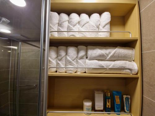 釜山Elbon The Stay的浴室内带白色毛巾和书籍的衣柜