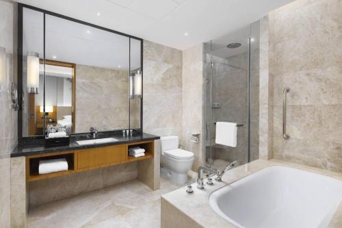 郑州郑州汇艺万怡酒店的带浴缸、卫生间和盥洗盆的浴室