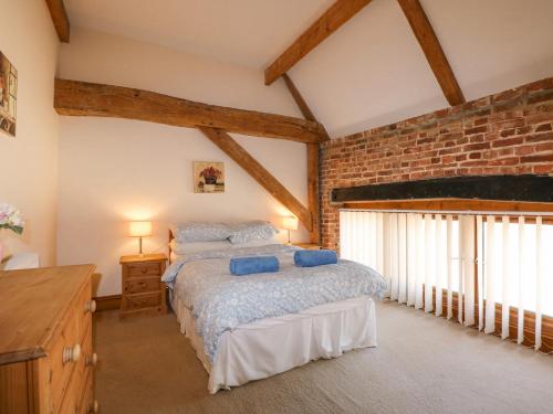 盖顿Hadleigh Farm Barn的一间卧室设有一张床和砖墙