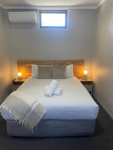 利斯莫尔Lismore Fair Dinkum Motel的卧室配有白色的床和2个枕头