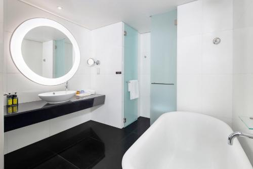 香港荃湾西如⼼酒店的白色的浴室设有水槽和镜子