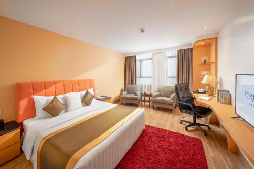 河内河内财神酒店的酒店客房设有一张大床和一张书桌。