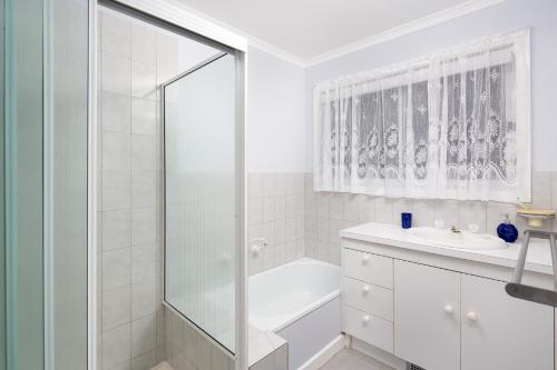 Rhyll9 Tunbridge Street的带淋浴和盥洗盆的白色浴室