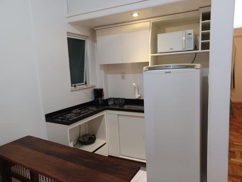 里约热内卢Apartamento Jardim Botânico的小厨房配有白色橱柜和冰箱。