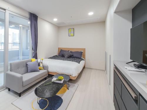 济州市Jeju Centerpoint N Residence的一间卧室配有一张床、一张沙发和一台电视。