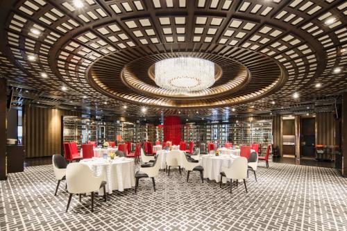 青浦上海虹桥西郊假日酒店的一间带桌椅的用餐室和大型天花板