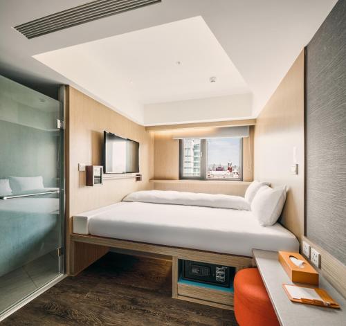 台北福泰桔子商旅 - 西门店的一间卧室设有一张大床和一个窗户。