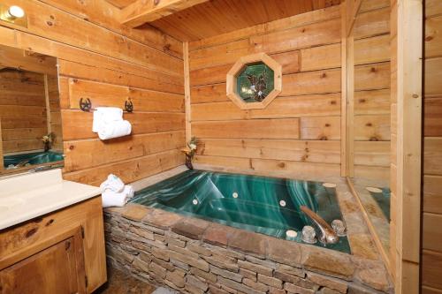 鸽子谷A Mountain Surprise的小木屋浴室内的按摩浴缸