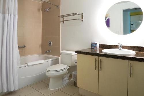 迈阿密Stunning 12th Floor Studio In The Heart Of Grove的浴室配有卫生间、浴缸和水槽。