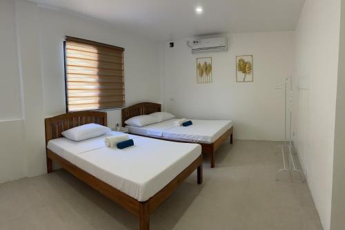 公主港Kasamigos Guesthouse with Fast Internet的带窗户的客房内的两张床