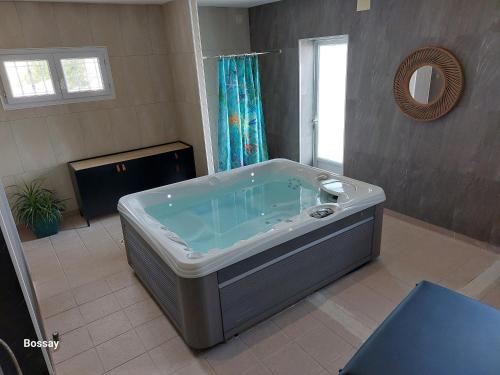 奥雷龙圣但尼L'insulaire Studios的带窗户的浴室设有大浴缸