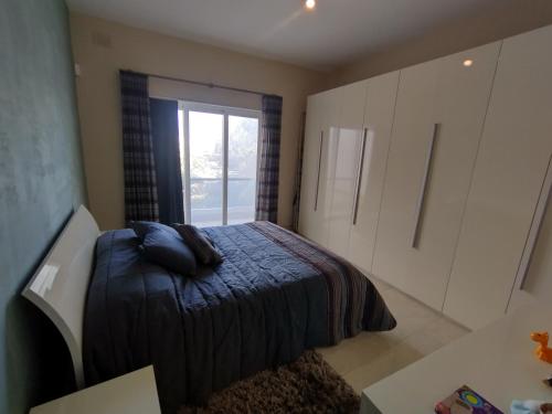 KirkopThe Luxury Home - Next to airport!的一间卧室设有一张床和一个窗口