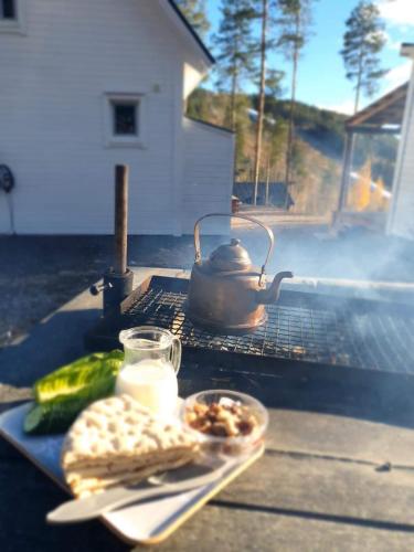 哈拉斯Stuga i Storklinten的茶壶和烤架上的一盘食物