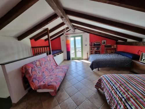 RifreddoCasa Monte Bracco的卧室设有红色的墙壁、一张床和一张沙发