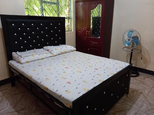 Boma la NgombeAirb&b Homestay的一间卧室配有一张带波尔卡点的床。
