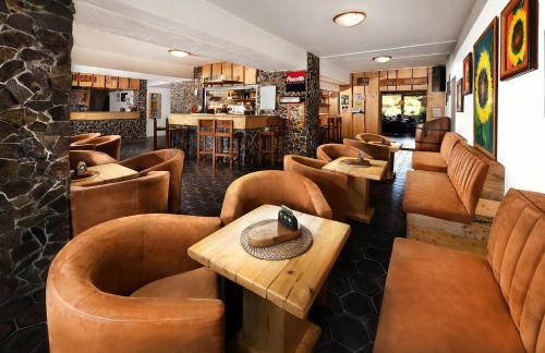 迪马诺卡多林纳利普托夫酒店的一间设有棕色桌椅的餐厅和一间酒吧