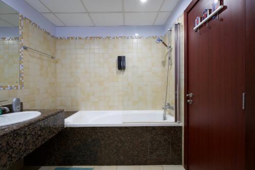 迪拜Charming spacious studio apartment in the heart of JBR By SWEET HOMES的带浴缸和盥洗盆的浴室