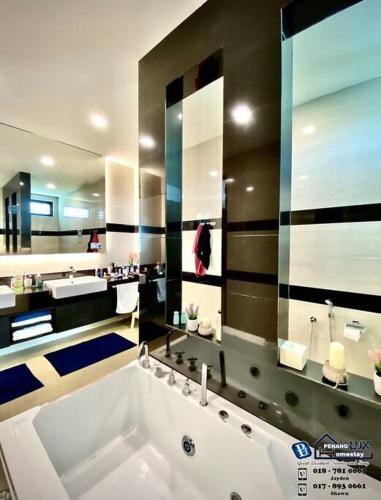 峇都丁宜Batu Ferringhi Luxurious Modern Designed 5BR House的一间带大浴缸和大镜子的浴室