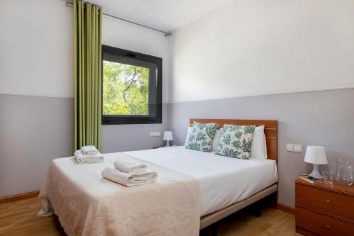 巴塞罗那萨塔古埃尔公园公寓酒店的一间卧室配有带毛巾的床
