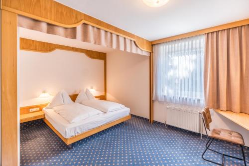 格拉茨克恩布阿姆酒店的酒店客房设有床和窗户。