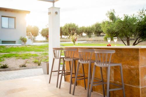 新马尔马拉斯Alikon Adult-Only的庭院设有带椅子和酒杯的酒吧