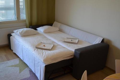拉赫蒂Lahti Center House的一间卧室配有一张大床,上面放有两个托盘