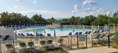 格罗斯皮耶尔雷Duplex (5pers) dans village vacances en Ardèche的一个带椅子和遮阳伞的大型游泳池