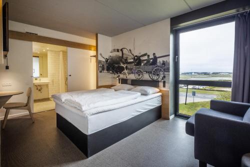 比伦德Airport Hotel, Billund的一间卧室设有一张大床和一个大窗户
