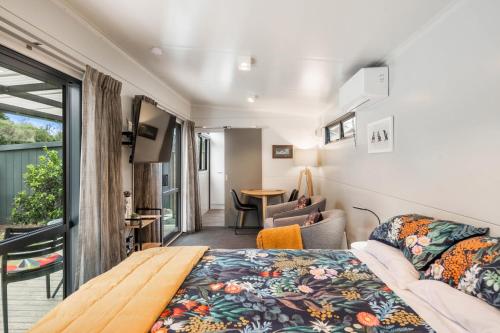 图朗伊Birdsong - Turangi Holiday Unit的一间卧室设有一张床和一间客厅。