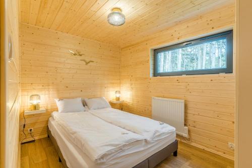 凯蒂赖贝西Bursztynowo的小木屋内一间卧室,配有一张床
