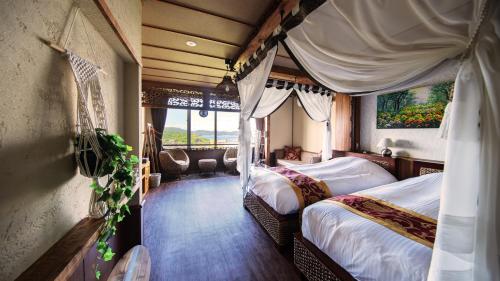 鸟羽Bali Resort SAYA no Kaze的酒店客房设有两张床和窗户。