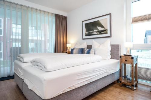卡珀尔恩Koje No1的卧室设有一张白色大床和一扇窗户。