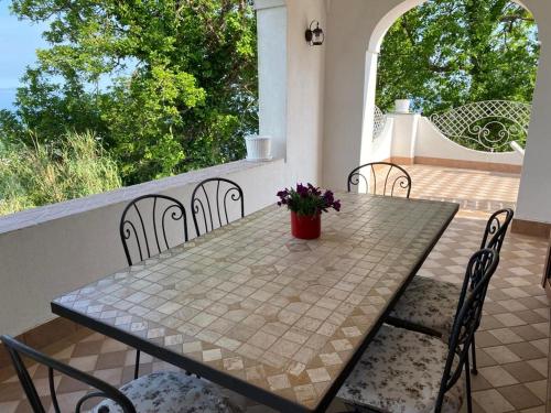 伊斯基亚Kiara Villas的庭院配有桌椅和桌子