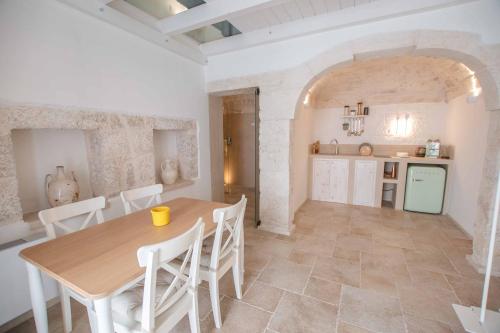 奥斯图尼Le Bianche Suites Ostuni的厨房以及带桌椅的用餐室。