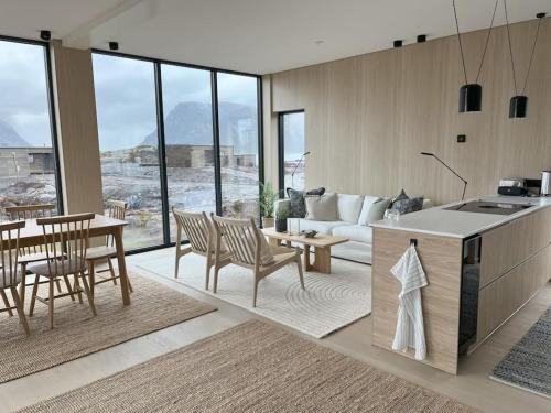 LyngværetLuksushytte med Jacuzzi, Summer&Winter Retreat的厨房以及带桌椅的起居室。