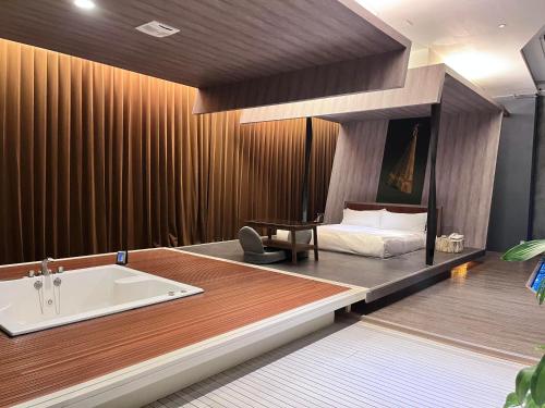 台中市天月人文休闲汽车旅馆 的一间卧室配有一张床和一个浴缸。