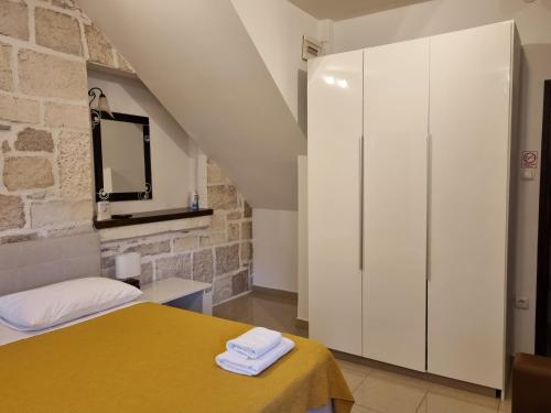 扎达尔Guest House Renata1的一间卧室配有黄色的床和白色橱柜