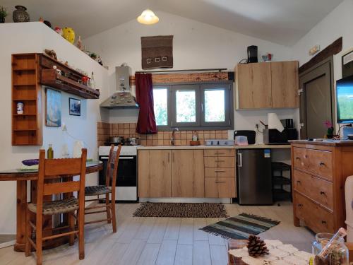 加拉塔斯Olea Cottage的厨房配有木制橱柜和桌椅