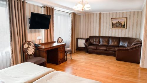 利沃夫利沃夫酒店的带沙发和书桌的酒店客房