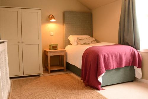ScourieScourie Hotel的小卧室配有一张带粉色毯子的床