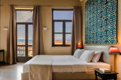 干尼亚阿卡内尔精品酒店的一间卧室设有一张大床和两个窗户。