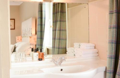ScourieScourie Hotel的浴室配有盥洗盆、镜子和毛巾