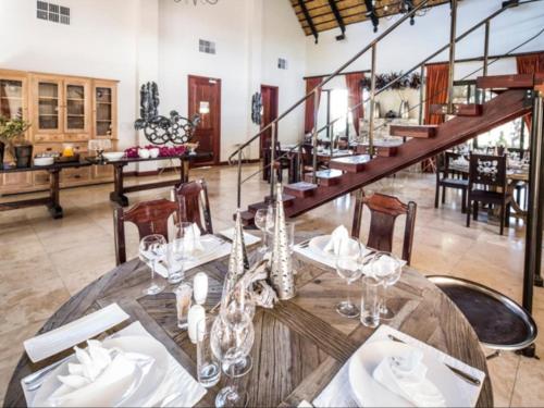 楚梅布La Rochelle Lodge Namibia Tsumeb的一间带桌子和楼梯的用餐室