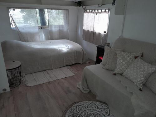 洛尔格Domaine d'Avalon的一间卧室配有一张床、一张沙发和一个窗口