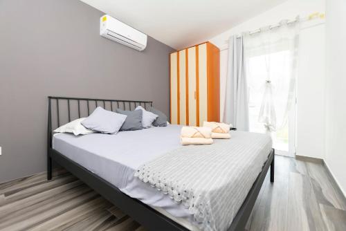 PodšpiljeHouse Coso的一间卧室配有一张带白色床单的床和一扇窗户。