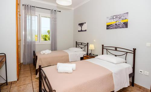 拉基索拉Aristotelis Apartment Lakithra-Alexandra的客房设有两张床和窗户。
