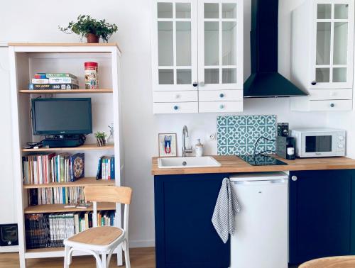 基伯龙Studio Tehani的厨房配有蓝白色橱柜和水槽